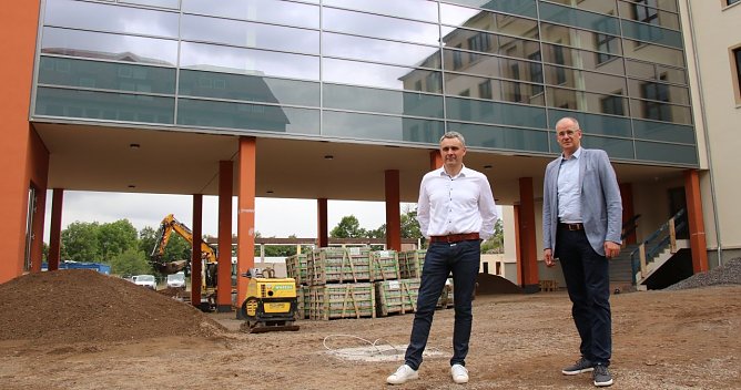 Auf der Zielgeraden: Service-Chef Gunnar Reuter und Landrat Matthias Jendricke auf dem Schulhof des neuen Humboldt-Gymnasiums (Foto: agl)