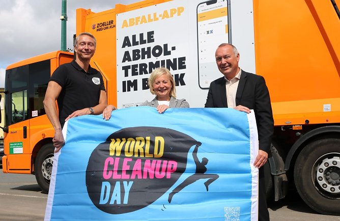 Holger Holland, Initiator des World Cleanup Days in Deutschland und EU Klimapakt-Botschafter &uuml;berreicht symbolisch die WCD-Fahne  Kathrin Materlik und Dirk Schimm (Foto: Pressestelle Landratsamt)