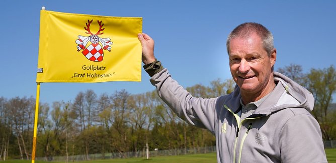Andreas Meyer, Pr&auml;sident des Neust&auml;dter Golfvereins, zeigt eine Fahne mit dem neuen Namen des erweiterten Golfplatzes.  (Foto: Susanne Schedwill)