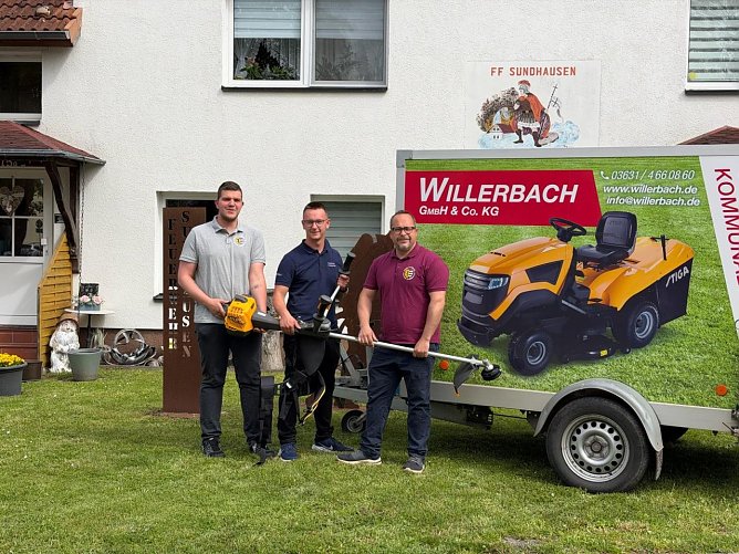 Willy Wackerhagen &uuml;berreicht die neue Motorsense.  (Foto: Feuerwehr Sundhausen)