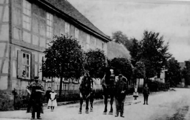 Ein eiserner Zaun und B&auml;ume s&auml;umten einst das ehemalige Gutshaus. Pferdefuhrwerke finden sich heute keine mehr. Dem Dorfschmied ging die Arbeit nicht aus.