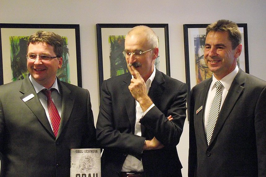 Vorstandsvorsitzender der Kreissparkasse Wolfgang Asche (rechts) und Thomas Seeber, Mitglied des Vorstandes, pr&auml;sentieren mit Sergej Lochthofen  (Mitte) dessen neuen Roman Grau.