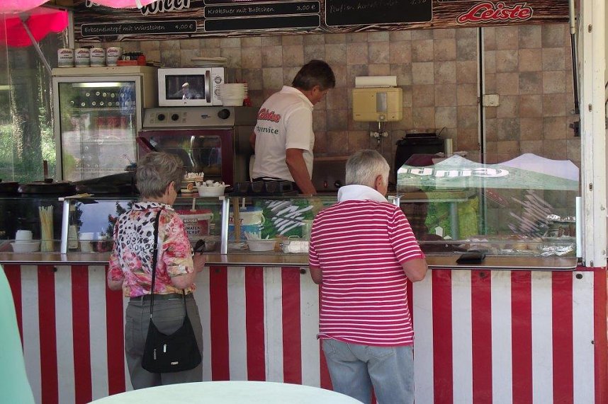 Vor dem Gasthaus hantiert Willi Allroth in seinem Imbiss-Wagen. Er steht in  Diensten der Marienteich Baude. Wer es auf die Schnelle mag, ist bei ihm an der richtigen Stelle.