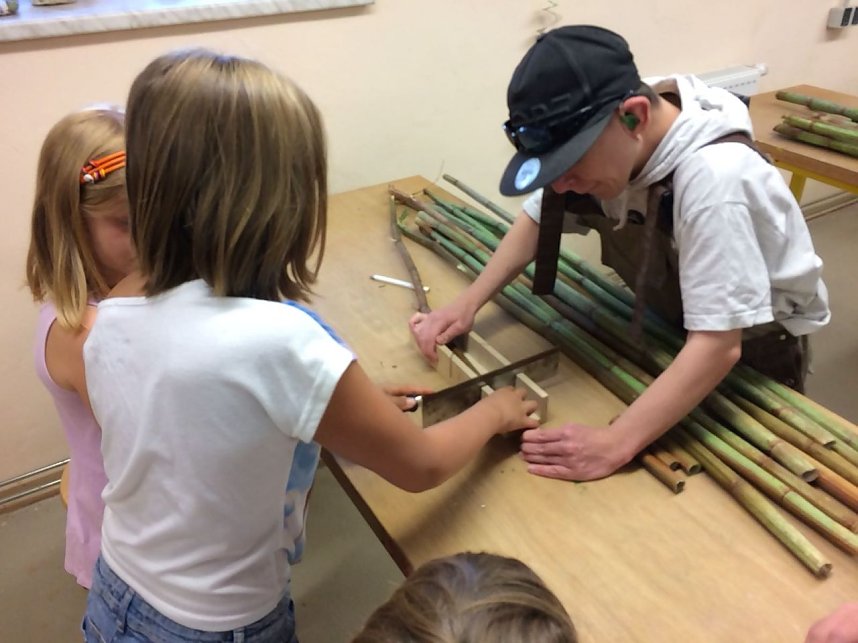 F&uuml;llmaterial f&uuml;r Insektenhotel wird zugeschnitten und eingebracht