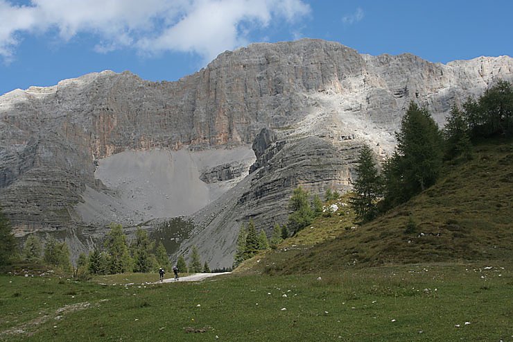 Sehr kleine Fahrradfahrer vor sehr gro&szlig;en Bergen.