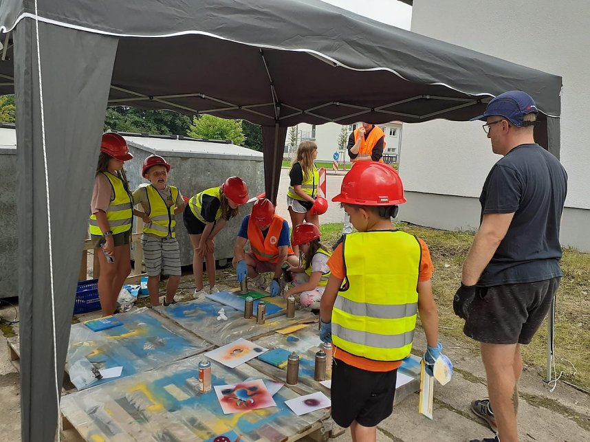 Projektteilnehner mit ihren Entw&uuml;rfen vor den einger&uuml;steten Silos